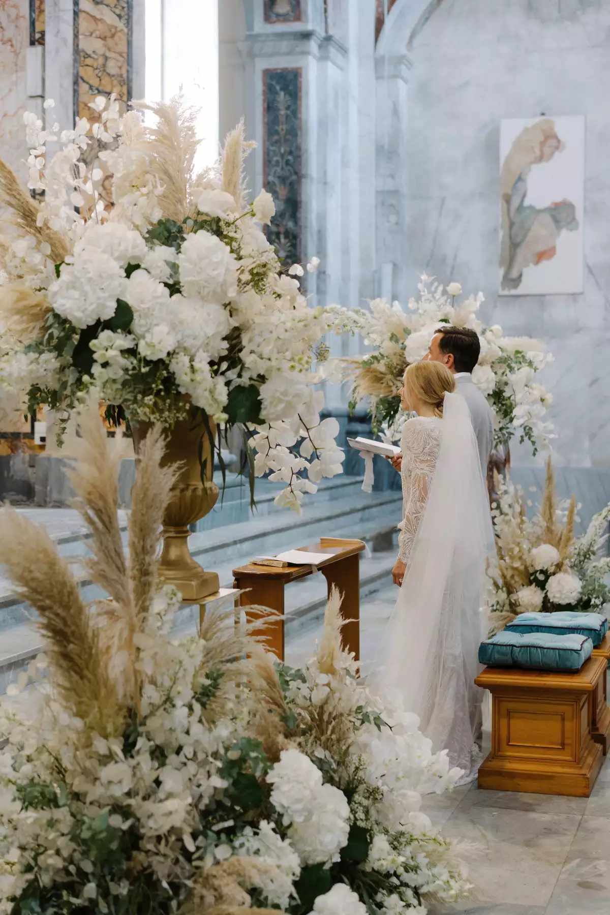 Elegant wedding reception table setup with white floral centerpieces.