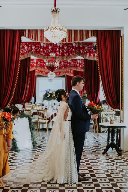 Elegant wedding reception setup with white floral centerpieces, gold-rimmed plates, and soft candlelight